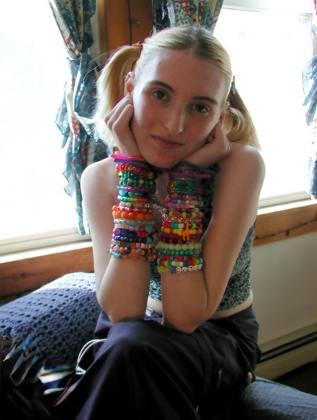 Young blonde Cricket gets naked on a sofa in pigtails and bangles 95649786