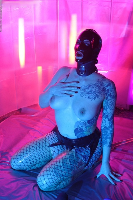 Tattooed chick Michelle Aston toys her pussy while sporting a black latex hood 27580194