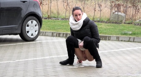 Solo girl Eveline Neill squats for a piss in a parking lot in winter clothing 27653432