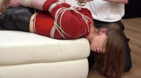Fully clothed girl finds herself hogtied and gagged on an ottoman 34218053
