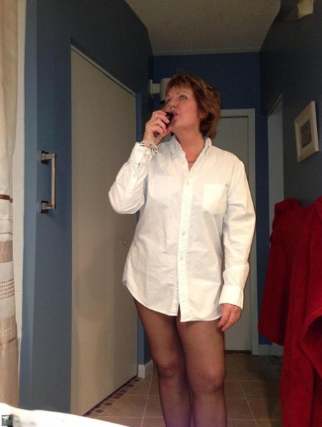 Older amateur Busty Bliss raises a toast before showing her painted toenails 95142764