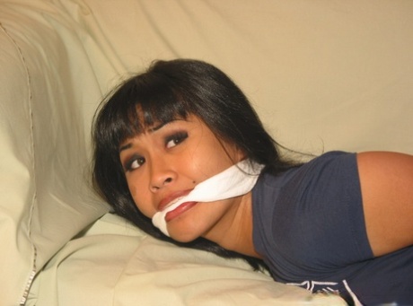 Solo girl with painted toenails is hog tied & gagged on a sofa in her clothes 99168980