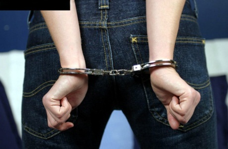Clothed woman looks nonplussed about being restrained with handcuffs 36270960
