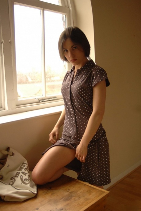 Solo girl slips off her dress and underthings in front of a window 94422337